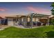 Charming backyard featuring a covered patio, green lawn, and easy access to the home, ideal for outdoor living at 2910 S Olivewood --, Mesa, AZ 85212