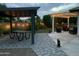 Backyard with brick pavers and string lights, featuring a covered picnic area and a seating area at 2910 S Olivewood --, Mesa, AZ 85212