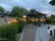 Evening view of a landscaped backyard featuring a covered picnic table area and low-maintenance landscaping at 2910 S Olivewood --, Mesa, AZ 85212