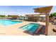Relaxing community pool area with lounge chairs, shaded seating, and a separate spa for residents at 2910 S Olivewood --, Mesa, AZ 85212