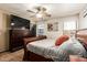 Comfortable bedroom featuring a ceiling fan, dresser with TV, and decor at 3032 W Red Fox Rd, Phoenix, AZ 85083