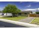 Charming home with lush green lawn, mature tree, and gravel driveway at 308 E La Jolla Dr, Tempe, AZ 85282