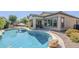 Relaxing backyard features a sparkling pool with desert landscaping, covered patio and string lights at 3280 E Coconino Dr, Gilbert, AZ 85298
