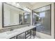 Bathroom featuring double sinks, stone backsplash, a large mirror, and tiled shower at 3280 E Coconino Dr, Gilbert, AZ 85298