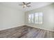 Bright bedroom with wood floors, a ceiling fan, and lots of natural light from two large windows at 3280 E Coconino Dr, Gilbert, AZ 85298