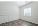 Bright bedroom features wood-look flooring, board and batten accent wall, and window with bright natural light at 3280 E Coconino Dr, Gilbert, AZ 85298