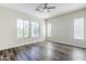 Bright bedroom with wood floors, a ceiling fan, and lots of natural light from three large windows at 3280 E Coconino Dr, Gilbert, AZ 85298