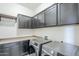 Laundry room features dark cabinets, front load washer and dryer, and shelf at 3280 E Coconino Dr, Gilbert, AZ 85298