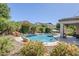 Beautiful backyard featuring a pebble tec pool, rock waterfall, desert landscape and lush greenery at 3280 E Coconino Dr, Gilbert, AZ 85298