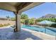 Inviting backyard pool with covered patio, lush landscaping, and privacy fence at 3280 E Coconino Dr, Gilbert, AZ 85298