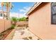 Backyard with covered patio, mature tree, a privacy fence, and stone landscaping at 3353 E Blackhawk Dr, Phoenix, AZ 85050