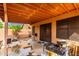 Covered patio has a grill, a table, and a door entering the home, all surrounded by a block fence at 3353 E Blackhawk Dr, Phoenix, AZ 85050