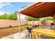 View of backyard with covered patio, grill, table, green grass, and block wall fence surrounding the property at 3353 E Blackhawk Dr, Phoenix, AZ 85050