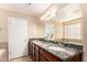 Bathroom featuring double sinks with granite countertops, and wooden cabinets at 3353 E Blackhawk Dr, Phoenix, AZ 85050