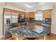 A well-equipped kitchen features stainless appliances, ample cabinetry, and elegant black marble countertops at 3353 E Blackhawk Dr, Phoenix, AZ 85050