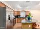 Modern kitchen with stainless steel appliances, granite countertops, wood cabinets, and kitchen island at 3353 E Blackhawk Dr, Phoenix, AZ 85050