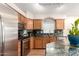 Bright kitchen featuring stainless steel appliances, granite counters, wood cabinets, and great lighting at 3353 E Blackhawk Dr, Phoenix, AZ 85050