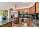 Stylish kitchen boasting stainless steel appliances, granite countertops, wood cabinets, and kitchen island at 3353 E Blackhawk Dr, Phoenix, AZ 85050