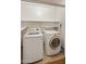 Laundry room featuring front load washer and dryer, tile floor and storage shelves at 3353 E Blackhawk Dr, Phoenix, AZ 85050