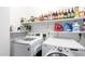 Bright laundry room featuring washer, dryer, and shelving with ample storage space for supplies and household goods at 3353 E Blackhawk Dr, Phoenix, AZ 85050
