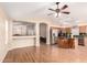 Open-concept living space featuring wood floors, ceiling fan, and seamless flow into the kitchen at 3353 E Blackhawk Dr, Phoenix, AZ 85050