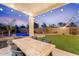 Covered patio with an outdoor dining area, string lights, lush synthetic grass and beautiful pool at 3604 E Derringer Way, Gilbert, AZ 85297