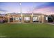 Expansive backyard with lush lawn, covered patio, and charming string lights, perfect for outdoor living and entertaining at 3604 E Derringer Way, Gilbert, AZ 85297