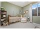 Bedroom with a crib, white chair, soft carpet and bright window at 3604 E Derringer Way, Gilbert, AZ 85297