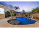 Backyard pool with lush landscaping, rock features, and umbrella in a tranquil setting at 3604 E Derringer Way, Gilbert, AZ 85297