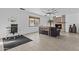 Comfortable living room featuring a brick fireplace, ceiling fan, tiled flooring, and a work area at 3754 W Hearn Rd, Phoenix, AZ 85053