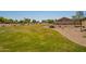 Large community common area with lush green grass, beautiful trees and gravel landscaping at 3815 S 64Th Ln, Phoenix, AZ 85043