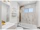 Modern bathroom featuring a sleek vanity, toilet, bathtub with designer shower, and luxurious tile surround at 3944 W Wilshire Dr, Phoenix, AZ 85009