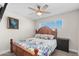 Bedroom featuring floral bedding, natural light, and a ceiling fan for comfortable living at 3944 W Wilshire Dr, Phoenix, AZ 85009