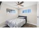Cozy bedroom with a ceiling fan, neutral walls, a large window, and comfortable bed with decorative bedding at 3944 W Wilshire Dr, Phoenix, AZ 85009