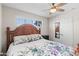 Bedroom featuring floral bedding, natural light, and a ceiling fan for comfortable living at 3944 W Wilshire Dr, Phoenix, AZ 85009