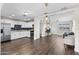 Open-concept living room and kitchen featuring modern appliances, white cabinets, and stylish pendant lighting at 3944 W Wilshire Dr, Phoenix, AZ 85009