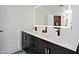This bathroom features a double sink vanity with black hardware, a large lighted mirror, and a marble countertop at 4039 E Paradise Dr, Phoenix, AZ 85028
