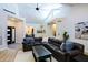 Bright living room with vaulted ceilings, clerestory windows, hardwood floors and a comfortable leather wraparound sofa at 4039 E Paradise Dr, Phoenix, AZ 85028