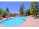 Sparkling community pool with lounge chairs and umbrellas, surrounded by mature trees and landscaping at 4039 E Paradise Dr, Phoenix, AZ 85028