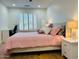 Bedroom features a cozy bed with a pink quilt, wood nightstands, lamps, and shutters at 4102 E Rancho Tierra Dr, Cave Creek, AZ 85331