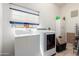 Bright laundry room with a window featuring a washer, dryer, and storage cabinet at 4102 W Bluefield Ave, Glendale, AZ 85308