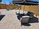 Enjoy an inviting patio with comfortable seating, umbrella, and attractive brick pavers at 4102 W Bluefield Ave, Glendale, AZ 85308