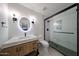 Modern bathroom with sleek vanity, circular mirror, and a glass-enclosed shower at 4202 E Catalina Dr, Phoenix, AZ 85018