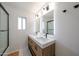 Modern bathroom featuring double vanity, stylish fixtures, and a glass-enclosed shower with white tiled walls at 4202 E Catalina Dr, Phoenix, AZ 85018