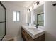 Sleek bathroom featuring double vanity, modern lighting, and a glass shower with tiled walls at 4202 E Catalina Dr, Phoenix, AZ 85018