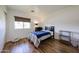 Cozy bedroom showcasing hardwood floors, a comfortable bed, and a well-lit window at 4202 E Catalina Dr, Phoenix, AZ 85018