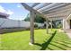 Lovely backyard features a covered patio area with shade from a wooden pergola at 4455 E Marshall Ave, Gilbert, AZ 85297