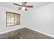 Comfortable bedroom with hardwood floors, ample natural light, and a modern ceiling fan, ensuring a relaxing space at 4455 E Marshall Ave, Gilbert, AZ 85297