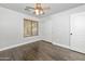 Bright bedroom features hardwood floors, a ceiling fan and a large window at 4455 E Marshall Ave, Gilbert, AZ 85297