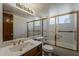 Bathroom with glass enclosed tub/shower combination, large vanity mirror, and ample lighting at 4627 E Mcneil St, Phoenix, AZ 85044
